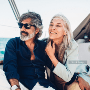 Older couple man and lady sitting on a boat smiling after surgery