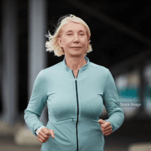 Older lady running in pale blue hoodie after surgery