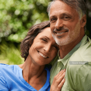 Couple of Laser Lens Replacement patients smiling outside and hugging after surgery