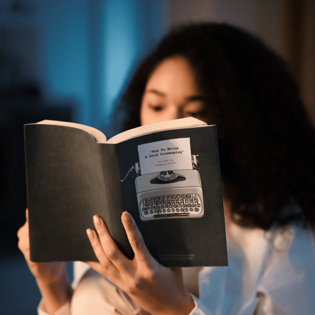 Girl with dark long hair reading paperback black book in dim light